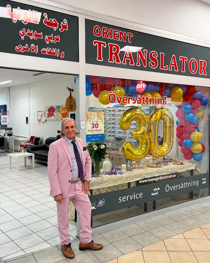 Muhsen Awad utanför Orient Translator i Rosengård Centrum, med ballonger för 30-årsjubileet